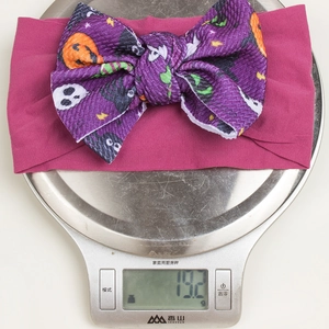 Detail of Halloween bow headband showing pumpkin ghost prints and waffle knit texture