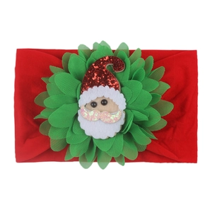 Detail of Christmas baby headband with green chiffon petals and Santa Claus motif