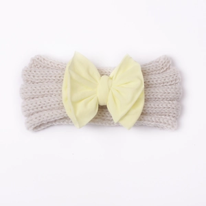 Detailansicht Baby-Stirnband mit cremeweißer Strickstruktur und gelber Schleife