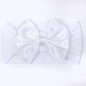 Détail d'un bandeau blanc pour bébé avec un grand nœud double élégant en satin soyeux