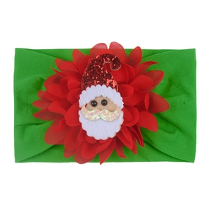 Detail of Christmas baby headband with red flower and sequined Santa Claus decoration