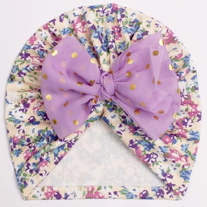 Détail du turban pour bébé en tissu côtelé fleuri avec un nœud en tulle violet doré