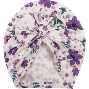 Close-up of baby turban hat with purple floral print and large decorative bow detail
