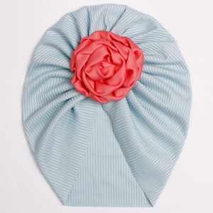 Close-up of ribbed light blue baby turban with a pink satin flower decoration
