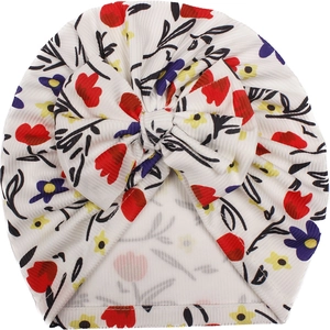 Floral print baby turban hat with a large decorative bow made of ribbed knit fabric