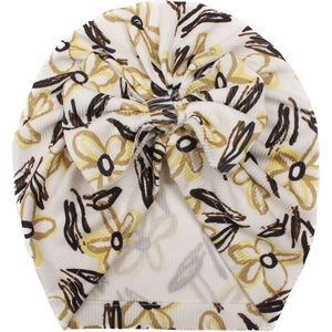 Detailed close-up of baby turban hat featuring floral prints and a large bow decoration