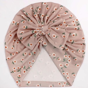 Detail of pink ribbed baby turban hat with white daisy floral print and large bow knot