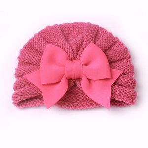 Bonnet en tricot doux pour bébé en rose foncé orné d'un grand nœud décoratif