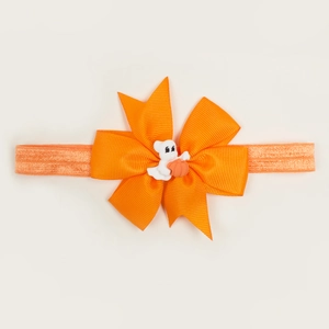 Détail du bandeau bébé Halloween avec nœud orange et breloque citrouille fantôme mignonne