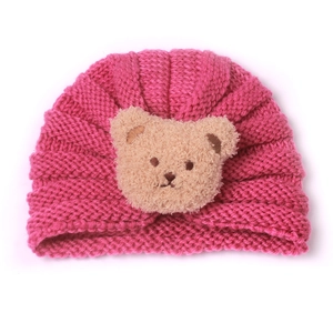 Pink knitted baby turban hat with a cute khaki plush bear patch for autumn and winter