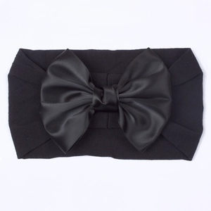 Elastische baby nylon hoofdband met een grote zwarte satijnen strik en zachte textuur