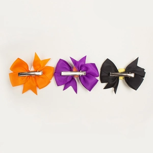 Rear view of three Halloween bow clips showing metal alligator clip attachments
