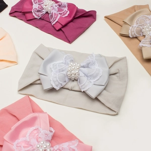 Détail de bandeaux pour bébés en nylon avec nœuds en dentelle et perles décoratives