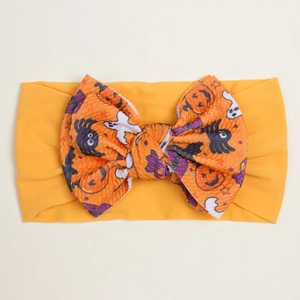 Detailed view of pumpkin and ghost print bow on wide orange baby Halloween headband
