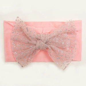 Detail of pink nylon baby headband with a large glittery mesh bow for infants