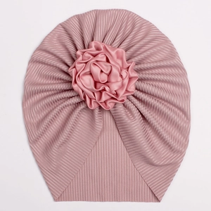 Pink ribbed baby turban with a large silk flower embellishment for newborns and toddlers