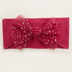 Detail of red elastic baby headband with large shimmering sequined mesh bow accessory