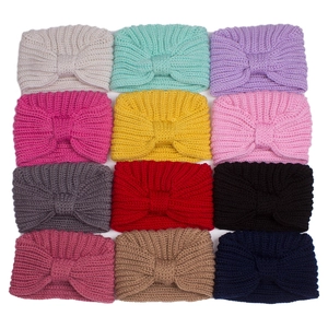 Flat lay of twelve colorful knitted baby headbands with a knotted bow design