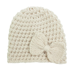 Close-up of cream knit baby beanie showing thick textured stitch and large bow detail