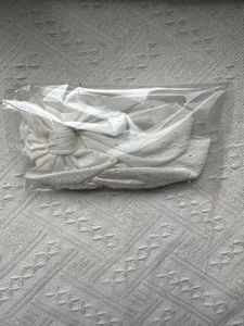 Vue détaillée du bandeau tricoté blanc ajouré avec nœud papillon sous emballage