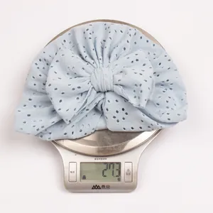 Detailed view of light blue eyelet baby turban with large bow weighing 27.3g