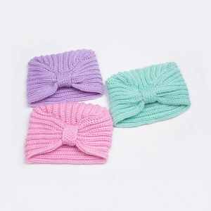 Three-piece set of ribbed knit baby beanies with oversized bows in pink, purple, and teal