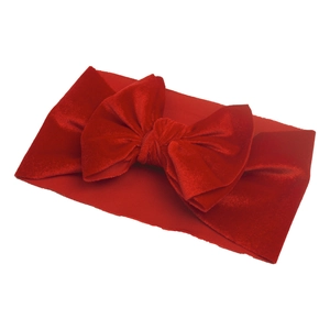 Detail of red velvet baby headband featuring a large bow and elastic soft fabric