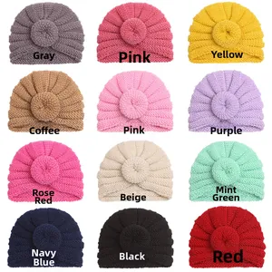 Detail view of baby donut knit hats in 12 assorted warm colors on a white background