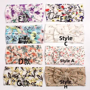 Detailed flat lay of eight soft baby headbands with various floral patterns and styles
