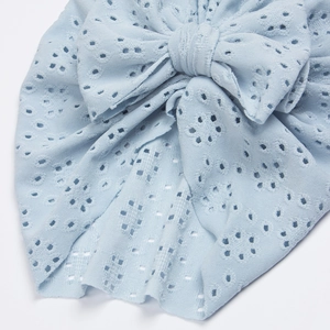Detailed view of light blue baby turban featuring hollow eyelet knit and a large bow