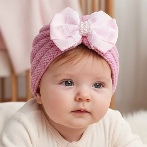 Vue détaillée du bonnet turban rose pour bébé avec nœud en satin dentelle et perle