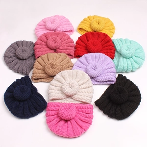 Variety of warm winter donut knitted hats for babies in eleven different solid colors