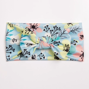 Close-up of baby floral bow headband with soft ribbed fabric and pastel print