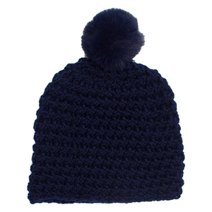 Detailed knit texture and fluffy pom-pom of the thick dark blue winter beanie hat