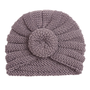 Close-up of purple knit baby donut hat showing textured rib knit and cross-wrap detail