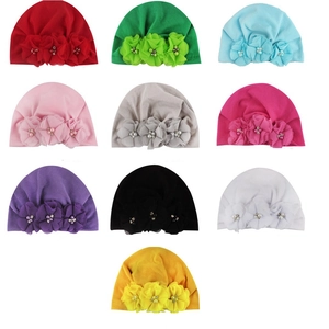Detail view of baby turban hats featuring chiffon flowers and inlaid pearls in ten colors