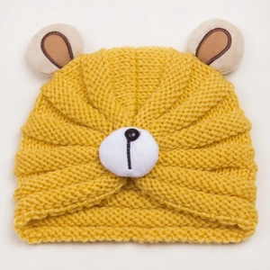 Detail view of ginger yellow knitted baby hat with bear ears and vertical texture