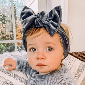 Détail d'une petite fille portant un bandeau en velours bleu avec un grand nœud décor