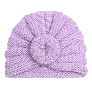Detailed texture of lavender knitted baby hat with donut knot on white background