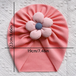 Detailed view of baby turban hat dimensions in pink waffle knit with large floral accent