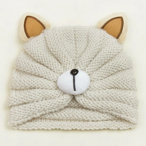 Detailed macro view of soft cream knit baby bear hat with cute 3D ears and plush nose