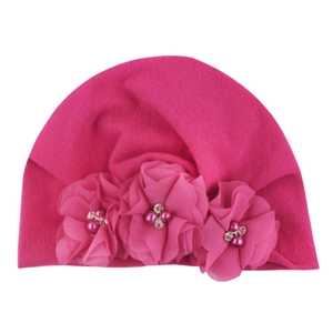 Detail of rose pink baby turban hat featuring soft fabric and three chiffon flowers with pearls