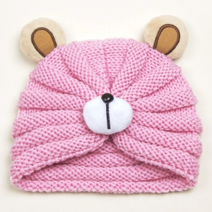 Detail of baby pink knit beanie featuring cute brown bear ears and plush white bear snout