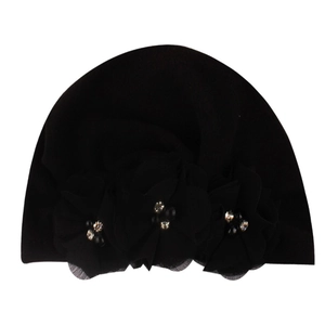 Close-up of black baby turban hat featuring elegant chiffon flowers and golden rhinestone beads