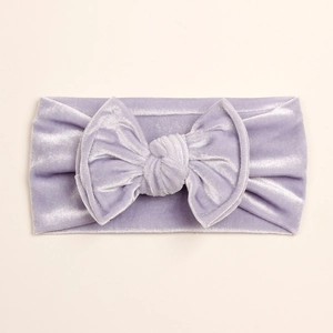 Détail du bandeau bébé en velours lavande avec un grand nœud et une texture côtelée