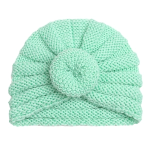 Detailed close-up of mint green knitted baby turban hat featuring center donut knot