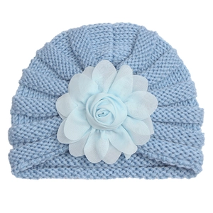 Détail du bonnet turban bleu clair pour bébé en tricot avec une grande fleur en tissu 3D