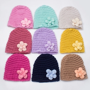 Nine colorful crochet baby knit beanies with 3D fabric flowers in various vibrant colors