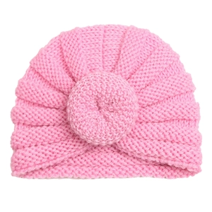 Close-up of pink knit baby turban hat featuring a soft texture and donut knot detail
