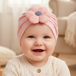 Detailed texture of baby girl pink knit turban hat with hollow-out floral design